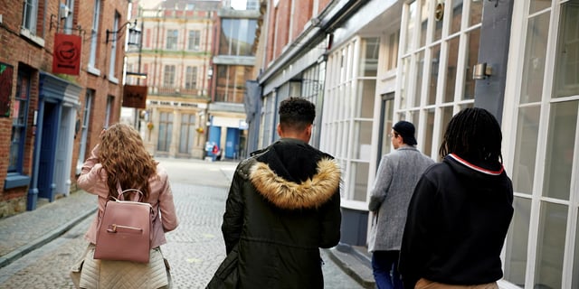 Students walk down brick street exterior. at Canvas Coventry Arundel House in Coventry Student Accommodation