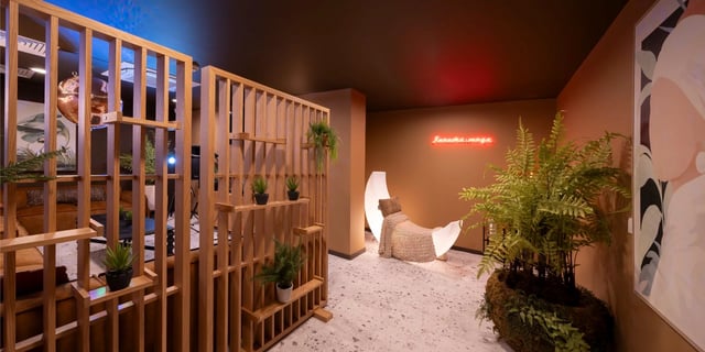 Wooden divider plants neon sign moon chair lounge at Canvas Glasgow in Glasgow Student Accommodation
