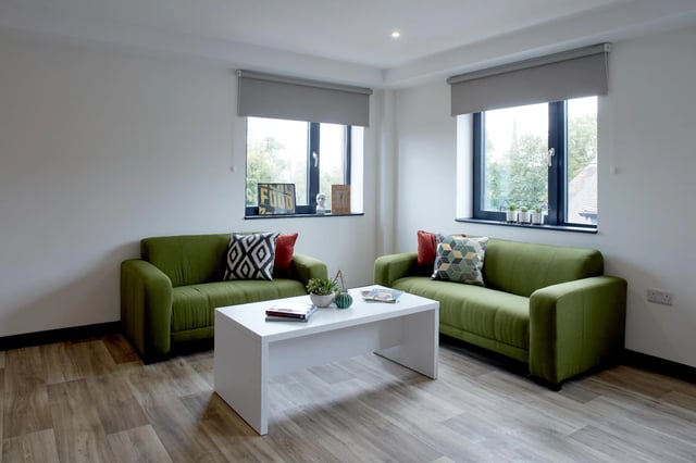 Two green sofas white table living room at Eden Square in Coventry Student Accommodation