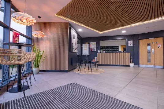 Reception desk chairs table plant lobby area at Riverside House - Manchester in Salford Student Accommodation
