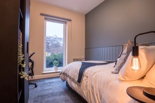 Bed with desk and bookshelf bedroom at Riverside House - Manchester in Salford Student Accommodation