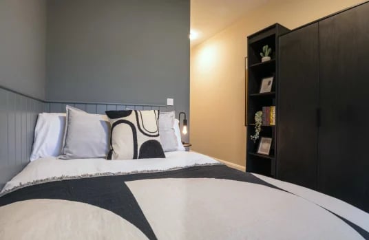 Bed with pillows shelf and wardrobe bedroom at Riverside House - Manchester in Salford Student Accommodation