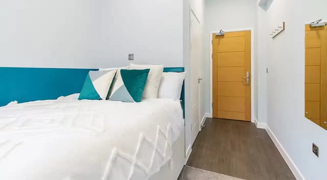 Bed with pillows and teal headboard bedroom at Urban Student Village in Coventry Student Accommodation