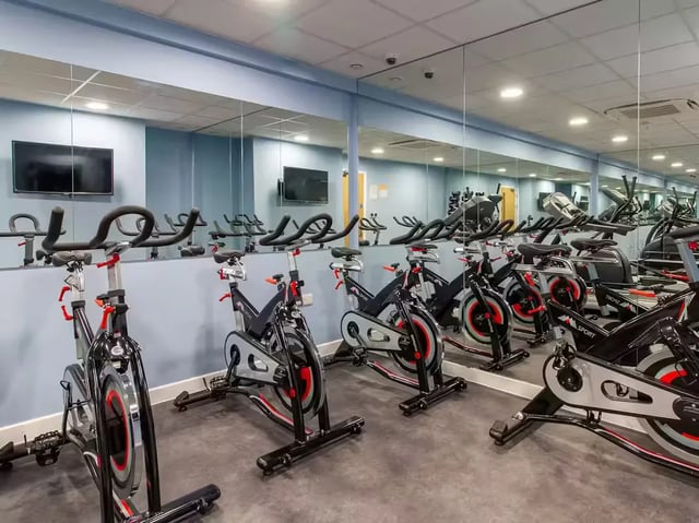 Spin bikes with mirrors and TVs gym at Urban Student Village in Coventry Student Accommodation