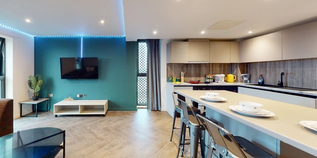 Modern open plan kitchen and living space with bar stools at Canvas Manchester in Manchester Student Accommodation