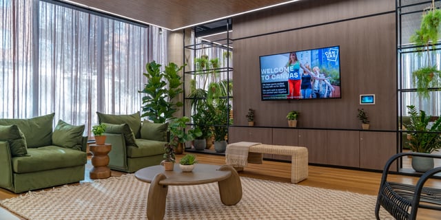 Green couches coffee table TV screen plants Living room at Canvas Manchester in Manchester Student Accommodation