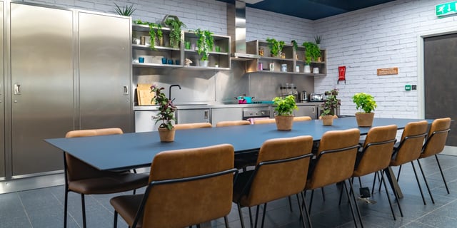 Metal lockers long table brown chairs kitchen at Canvas Manchester in Manchester Student Accommodation
