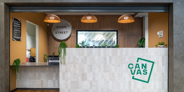 Reception desk with plants and logo reception area at Canvas Manchester in Manchester Student Accommodation