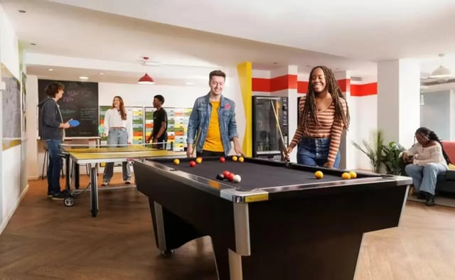 Students playing pool and ping pong common area. at Riverside Point in Nottingham Student Accommodation