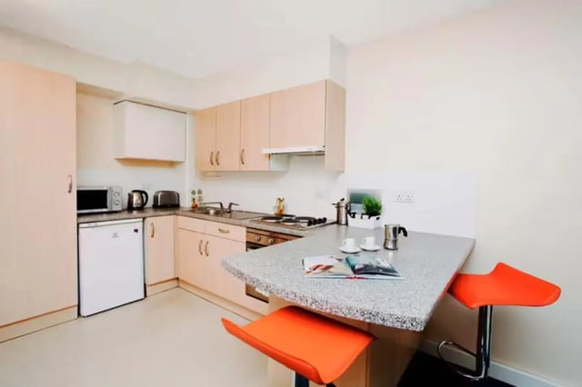 Kitchen with counter island two orange stools and appliances Kitchen at Riverside Point in Nottingham Student Accommodation