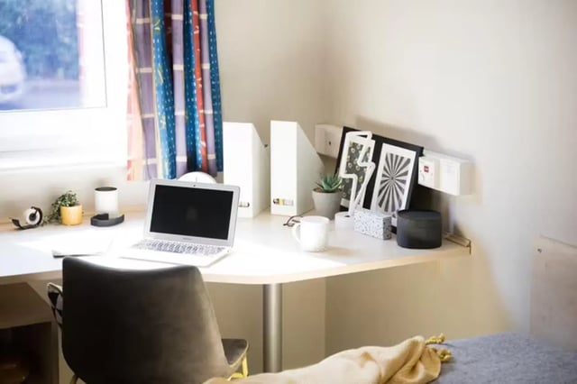 Desk with laptop mug plant frames study area at Riverside Point in Nottingham Student Accommodation