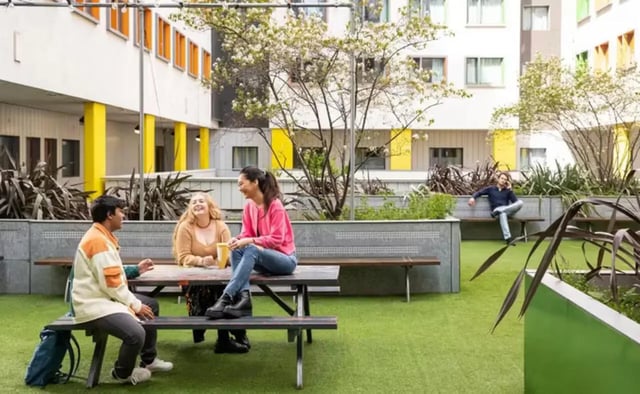 Students on picnic table and benches exterior at Emily Bowes Court in London Student Accommodation