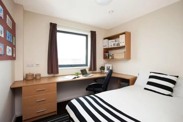 Desk bed shelving computer and pillows bedroom at Waterways in Loughborough Student Accommodation