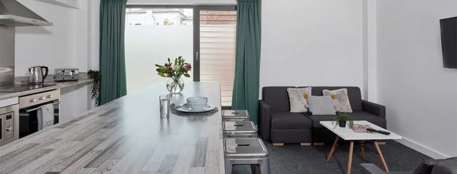 Kitchen island with seating and sofa living area at Selly Oak Apartments in Birmingham Student Accommodation