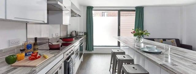 Kitchen counters with food and stools kitchen at Selly Oak Apartments in Birmingham Student Accommodation