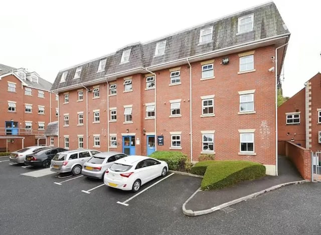 Red brick student accommodation building with parked cars exterior at Snowdon Hall in Wrexham Student Accommodation