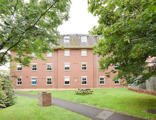 Brick building with picnic table on lawn exterior at Snowdon Hall in Wrexham Student Accommodation