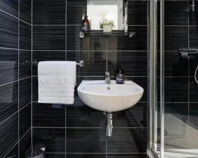 Sink with towel and shower stall bathroom at The Mews in Oxford Student Accommodation