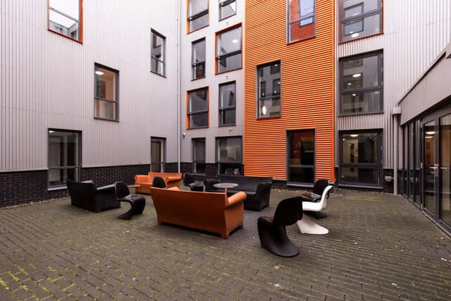 Courtyard with orange and grey buildings and seating area exterior at The Foundry Newcastle in Newcastle Upon Tyne Student Accommodation