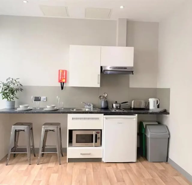 Counter with stools microwave fridge bins kitchen at Nottingham Two in Nottingham Student Accommodation