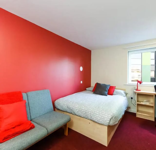 Bed sofa desk lamp red wall bedroom at Nottingham Two in Nottingham Student Accommodation