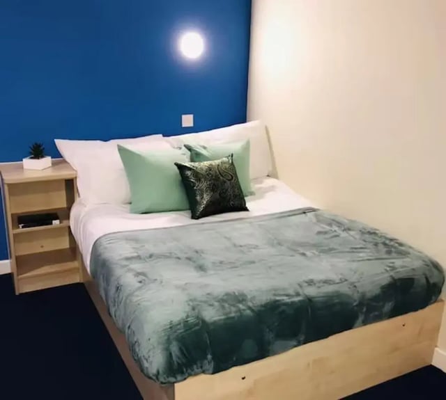 Bed with green pillows and blanket bedroom at Nottingham Two in Nottingham Student Accommodation