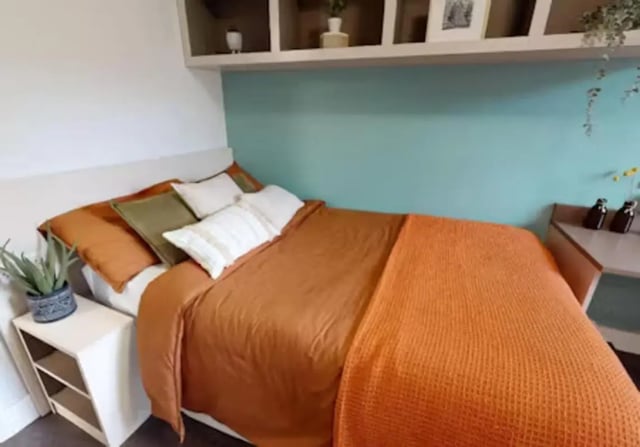 Bed with orange bedding and pillows bedroom at iQ Twerton Mill in Bath Student Accommodation