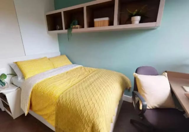 Bed with yellow bedding and desk with chair bedroom at iQ Twerton Mill in Bath Student Accommodation