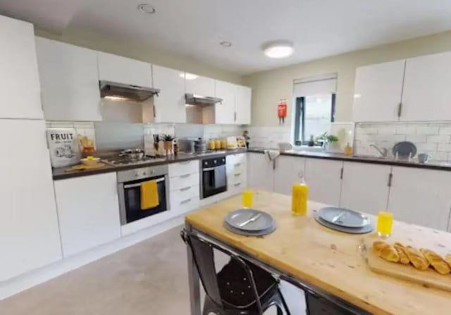 White cabinets ovens stove island table kitchen at iQ Twerton Mill in Bath Student Accommodation
