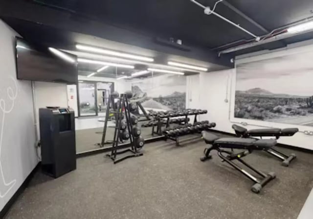 Dumbbell racks bench TV and trash bin gym at iQ Twerton Mill in Bath Student Accommodation
