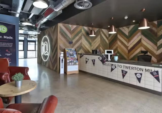 Reception desk with signage and seating lobby area at iQ Twerton Mill in Bath Student Accommodation