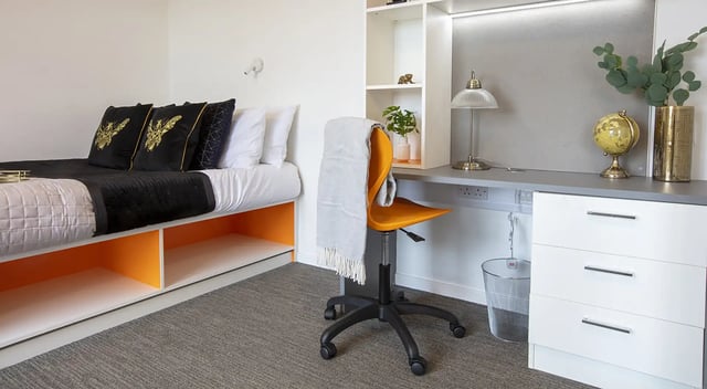 Bed with decorative pillows desk and drawers Bedroom at Fraser Studios in Aberdeen Student Accommodation