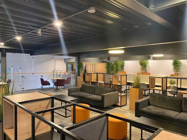 Sofas ottomans shelving plants shared lounge area at Fraser Studios in Aberdeen Student Accommodation