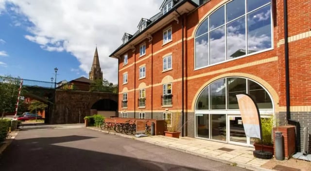 Red brick building with large arched windows exterior at Iron Bridge Studios in Exeter Student Accommodation