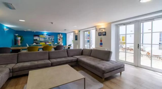 Grey sectional sofa coffee table study area living room at Iron Bridge Studios in Exeter Student Accommodation