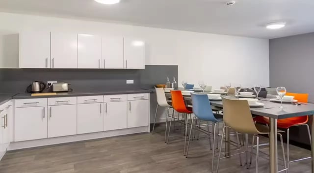 Counter with appliances and dining table with chairs kitchen at The Croft in Derby Student Accommodation