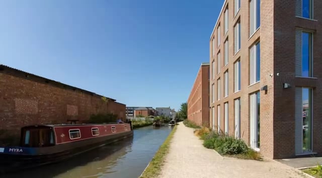 Modern brick building by canal with narrowboat exterior at The Union Leamington in Leamington Spa Student Accommodation