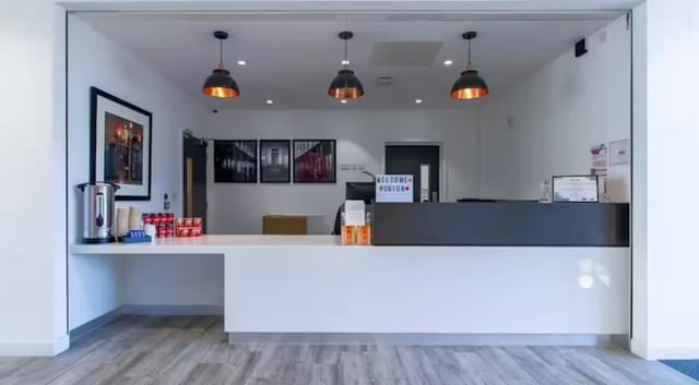 Reception desk with hot water dispenser and drinks front desk at The Union Leamington in Leamington Spa Student Accommodation