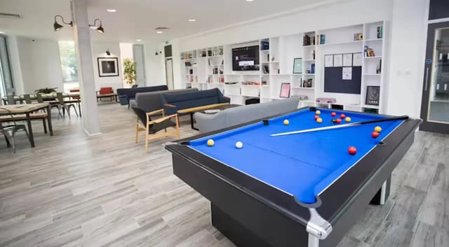 Pool table couches bookshelves and tables communal area at The Union Leamington in Leamington Spa Student Accommodation