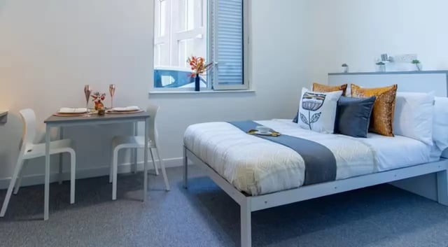 Bed table chairs and window bedroom at The Union Leamington in Leamington Spa Student Accommodation