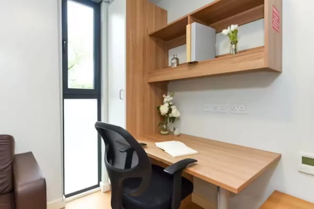 Desk chair shelves flowers laptop and window study area at The Summit Leicester in Leicester Student Accommodation