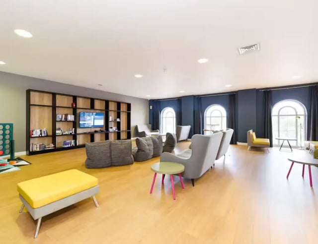 Sofa television bookshelf and seating living room at Upperton Road in Leicester Student Accommodation