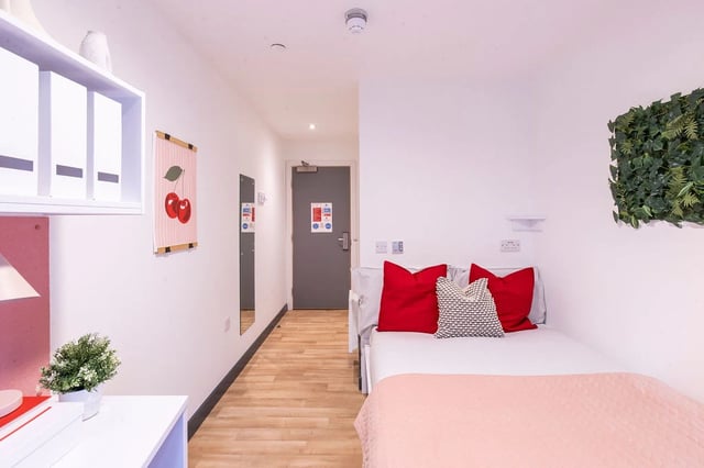 Bed with red pillows and plant wall Bedroom at Bailey Street in Sheffield Student Accommodation