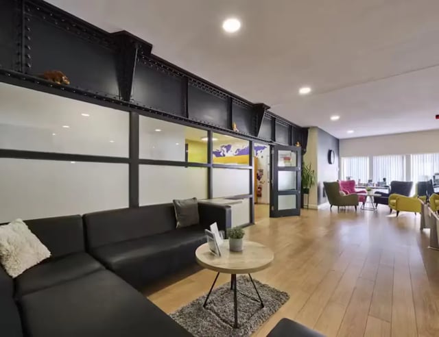 Black sectional sofa round coffee table living room at Upperton Road in Leicester Student Accommodation