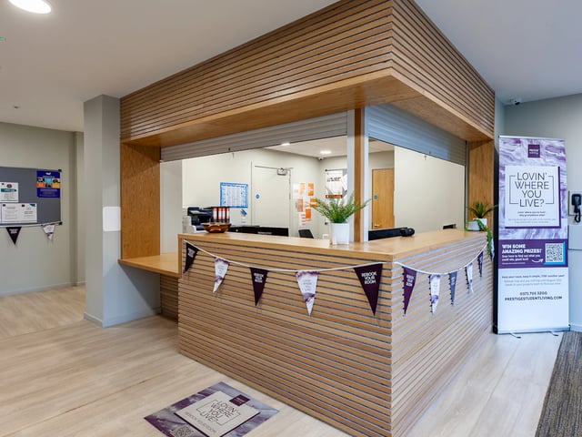 Reception desk with plants and banners reception area at Straits Meadows in Edinburgh Student Accommodation