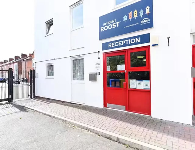 Red reception doors with signage and gate exterior at Queens Court Leicester in Leicester Student Accommodation