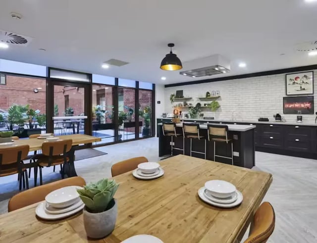 Dining tables with chairs and kitchen area communal space at York House in Nottingham Student Accommodation