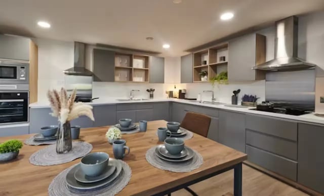 Wooden table with place settings and gray cabinets kitchen at York House in Nottingham Student Accommodation
