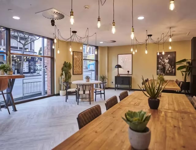 Wooden tables with plants and chairs communal area at York House in Nottingham Student Accommodation