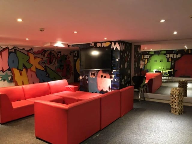 Red sectional sofa graffiti TV and gaming area at Horton House Bradford in Bradford Student Accommodation